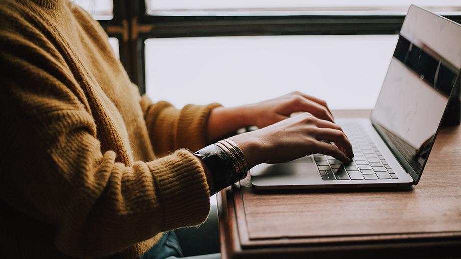 Person' hands typing on a laptop